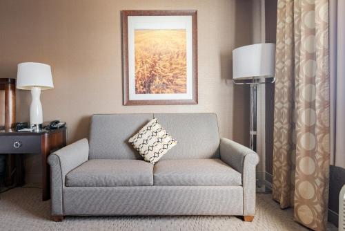 a living room with a couch with a pillow on it at Wyndham Omaha Hotel - West Dodge in Omaha