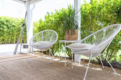 two white chairs and a table on a porch at The Beach Hut in Vincentia