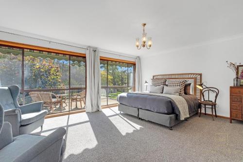 1 dormitorio con cama, sofá y balcón en Little Haven, Jervis Bay en Falls Creek