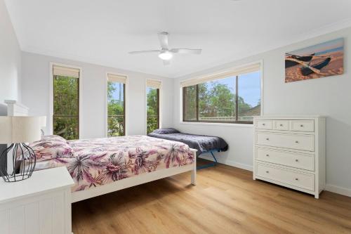 ビンセンチアにあるFamily Tides Beach Escapeのベッドとドレッサーと窓のある寝室