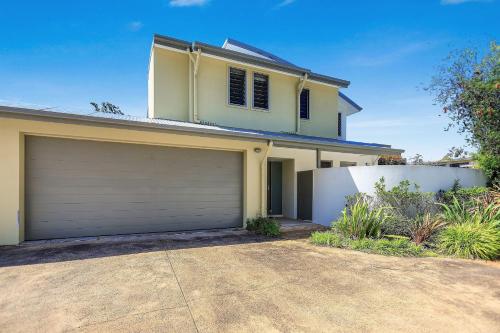 a white house with a garage at Coast Bliss on Currambene in Huskisson