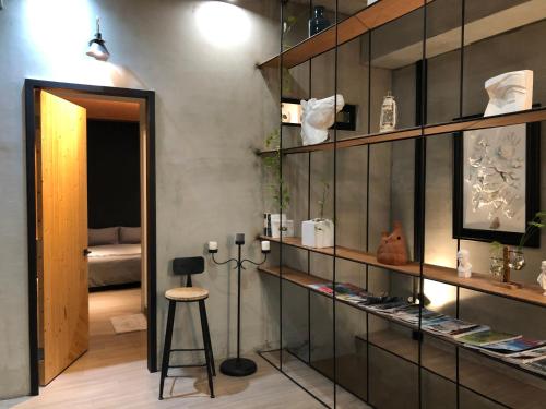 una stanza con ripiani in vetro e uno sgabello di 墾丁恆春包棟 l 洛夫特Looft民宿 a Città Vecchia di Hengchun