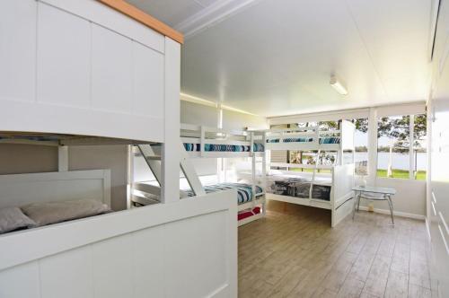 a bedroom with bunk beds and a room with a desk at Island Point Paradise in St Georges Basin