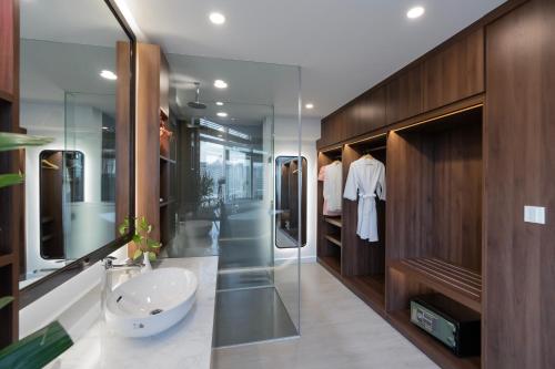 een badkamer met een wastafel en een spiegel bij ÊMM Hotel Saigon in Ho Chi Minh-stad