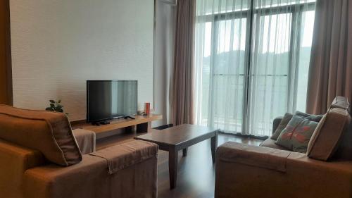 金馬崙高原的住宿－G Residence - 3R2B The Retreat, Aranda Nova, Cameron Highlands，客厅配有2把椅子和平面电视