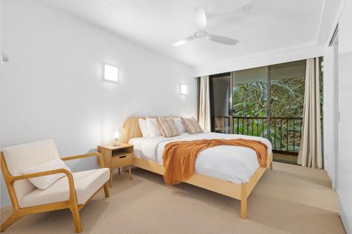 een slaapkamer met een bed, een stoel en een raam bij The Rocks Resort Unit 2C in Gold Coast