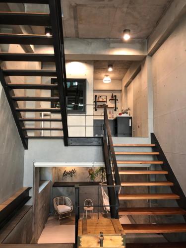 una escalera en un loft con mesa y sillas en 洛夫特Looft包棟民宿, en Hengchun