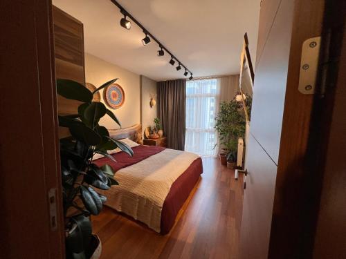 um quarto de hotel com uma cama e um vaso de plantas em A view from above the Ekinoks Mall for NightClups em Esenyurt