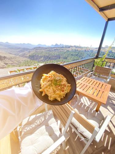 a pan of food sitting on a table on a balcony at Hissen Al-Misfah in Misfāh