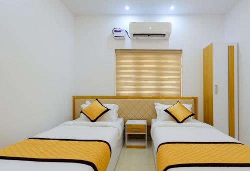 - une chambre avec 2 lits et la climatisation dans l'établissement Serene Stay, à Alappuzha