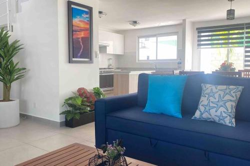 a blue couch in a living room with a kitchen at Hermosa casa en Acapulco con club de Playa. in Acapulco