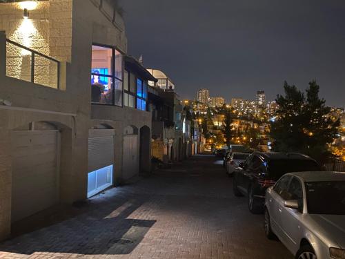 a city street at night with cars parked at Jerusalem MALHA View in Jerusalem