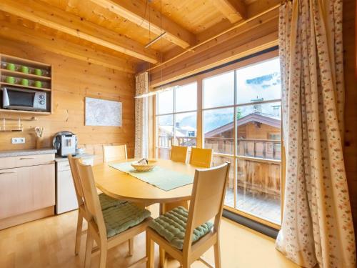 eine Küche und ein Esszimmer mit einem Tisch und einem großen Fenster in der Unterkunft Apartment near the ski area in Brixen im Thale