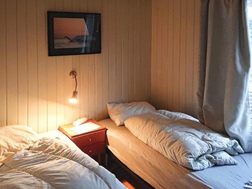 a room with two beds and a table with a lamp at Two-Bedroom Holiday home in Gravdal 1 in Gravdal