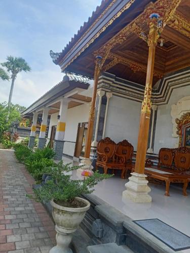 - un bâtiment avec 2 bancs et une terrasse couverte dans l'établissement D'pondok Batu Jaran, à Kubu