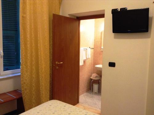 Cette chambre dispose d'une salle de bains et d'une télévision sur une porte. dans l'établissement Hotel Ricci, à Gênes