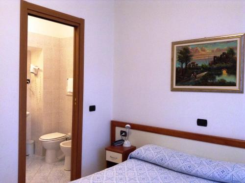 1 Schlafzimmer mit einem Bett und einem Bad in der Unterkunft Hotel Ricci in Genua