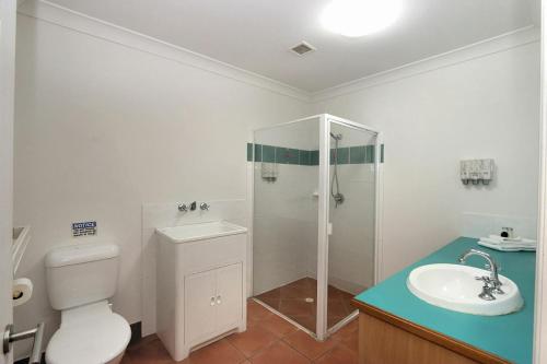 a bathroom with a shower and a toilet and a sink at Villa 25 Coral Cove Resort in Bargara