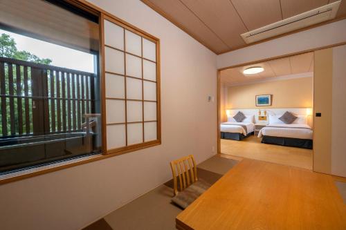 a room with two beds and a window at KAMENOI HOTEL Ome in Ome