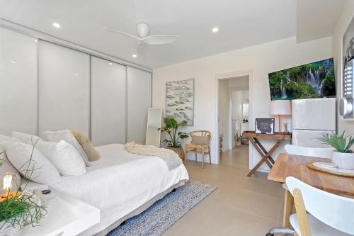 a living room with a white bed and a table at The Beach Studio in Huskisson
