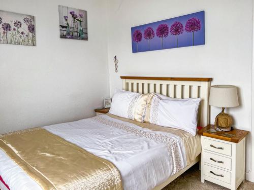 a bedroom with a bed and a table with a lamp at Ivy Court Apartment in Rothesay