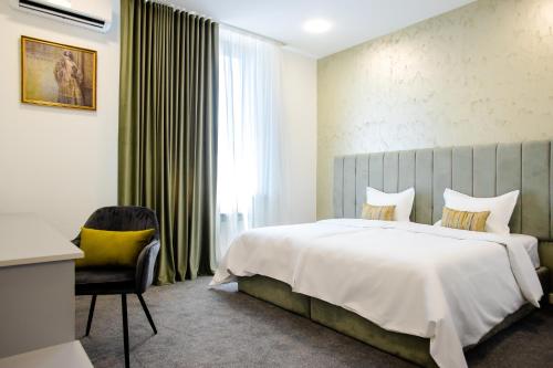 a bedroom with a large bed and a chair at Benefice Hotel Yerevan-通緝 in Yerevan