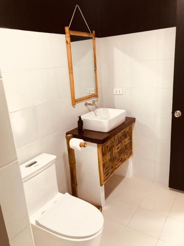 a bathroom with a white toilet and a sink at Everyday Sunday Hotel & Cafe in Bantayan Island