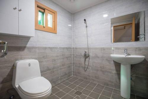 La salle de bains est pourvue de toilettes et d'un lavabo. dans l'établissement THE SOME PENSION, à Seogwipo