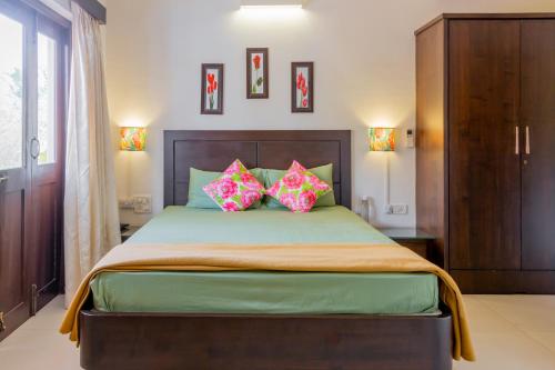 1 dormitorio con 1 cama grande y 2 almohadas rosas en Spacious 3 bhk new stylish villa in Vagator en Vagator