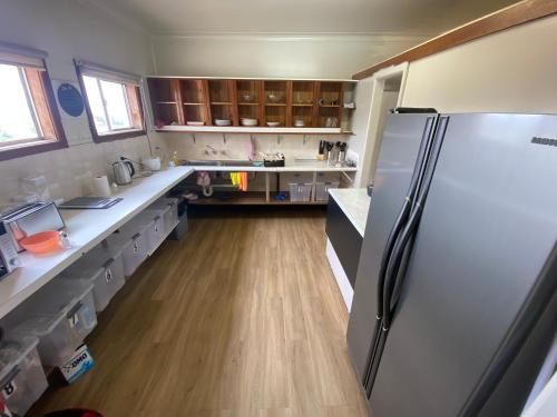 a large kitchen with a refrigerator and wooden floors at Normandie Wollongong in Wollongong