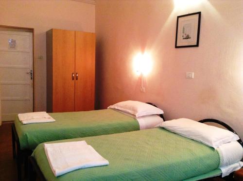 2 Betten in einem Zimmer mit Grün und Weiß in der Unterkunft Hotel Bernheof in Genua