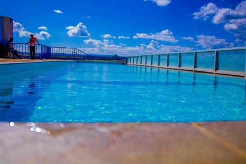 a pool of blue water with a bridge in the background at Josab Super Cosy Apartment. in Kiambu