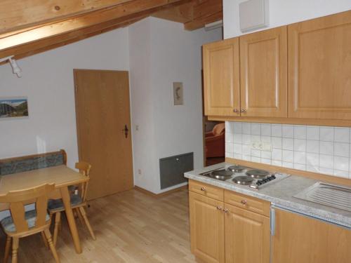 a kitchen with a table and a stove top oven at Lindenhof Inzell - FeWo mit Chiemgaukarte in Inzell