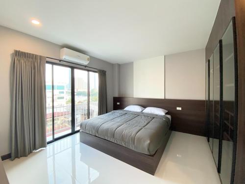 a bedroom with a bed and a large window at Mangkon Hostel in Bangkok
