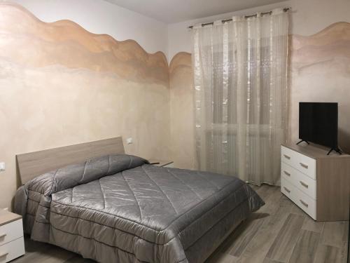 een slaapkamer met een bed en een flatscreen-tv bij WHITE HOUSE in Verona