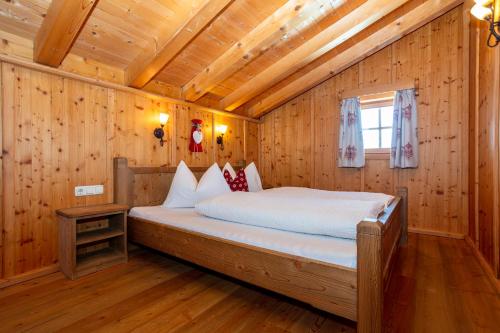 a bedroom with a bed in a wooden cabin at Apartment Grammlergut in Maria Alm am Steinernen Meer