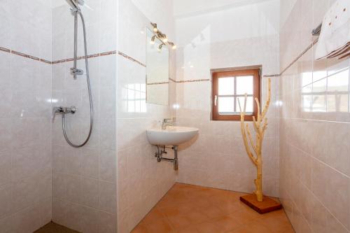 a white bathroom with a sink and a shower at Apartment Grammlergut in Maria Alm am Steinernen Meer