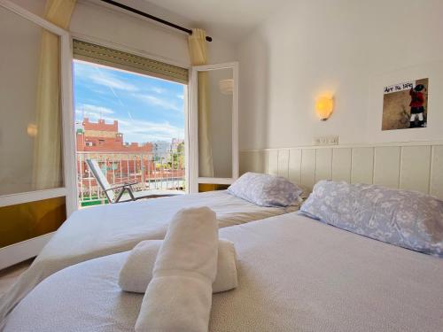 ロザスにあるAPARTAMENTOS AQUARIUM. (2A) PERFECT FOR 2.の大きな窓付きの客室で、ベッド2台が備わります。