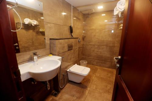 a bathroom with a sink and a toilet at Hotel Seven Hills in Trivandrum
