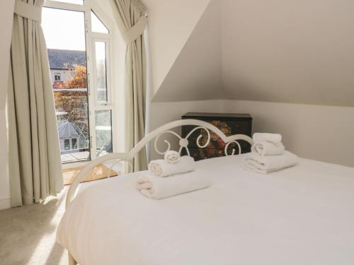 a bedroom with a white bed with towels on it at Beach House in Rhos-on-Sea