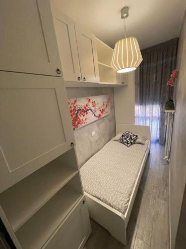 Cette petite chambre comprend un petit lit et des étagères. dans l'établissement Dave’s house, à Reggio d'Émilie