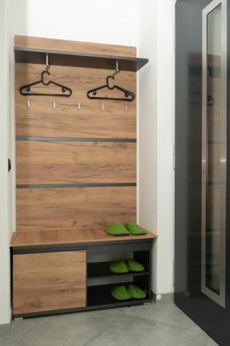 a closet with a wooden wall with green shoes at Alone in Chalet with view on Dolomites in Villandro
