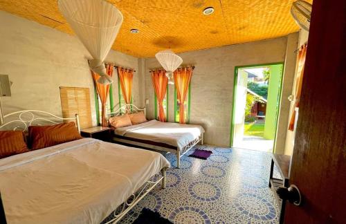 a bedroom with two beds and an open door at Rainbow House Pai in Pai