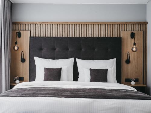 a large bed with a black headboard and white pillows at The Crystal VAYA Unique in Obergurgl