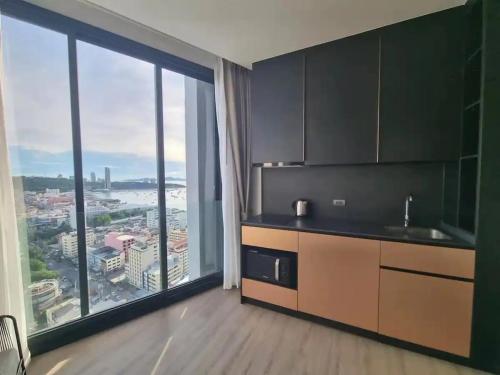 a kitchen with a large window with a view of a city at EDGE Central pattaya near walking street in Pattaya Central