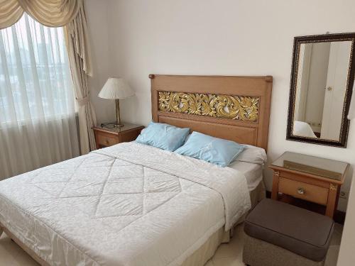 a bedroom with a large bed and a mirror at Batavia apartements in Jakarta