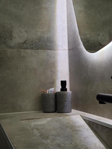 un baño con dos cubos de basura junto a un fregadero en Green point, en Sarajevo