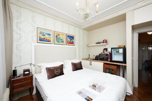 a bedroom with a white bed and a tv at Faik Pasha Hotels Special Category Beyoglu Istanbul in Istanbul