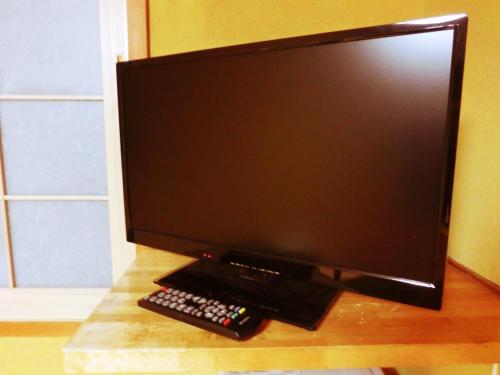 a computer monitor and a remote control on a desk at Oyado Uemasa in Nozawa Onsen