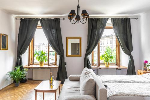 - une chambre avec un lit, un canapé et des fenêtres dans l'établissement Main Square 18 view 1, à Cracovie